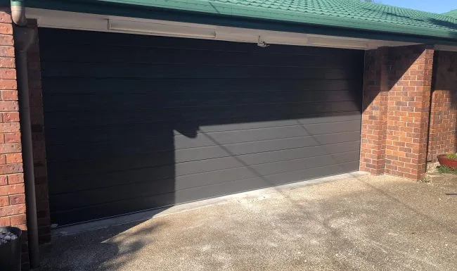 Charcoal sectional garage door fitted to a double brick garage