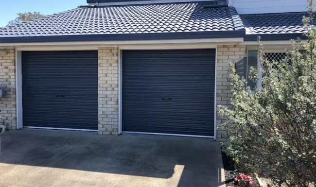 Twin charcoal roller doors fitted to adjoining garage openings